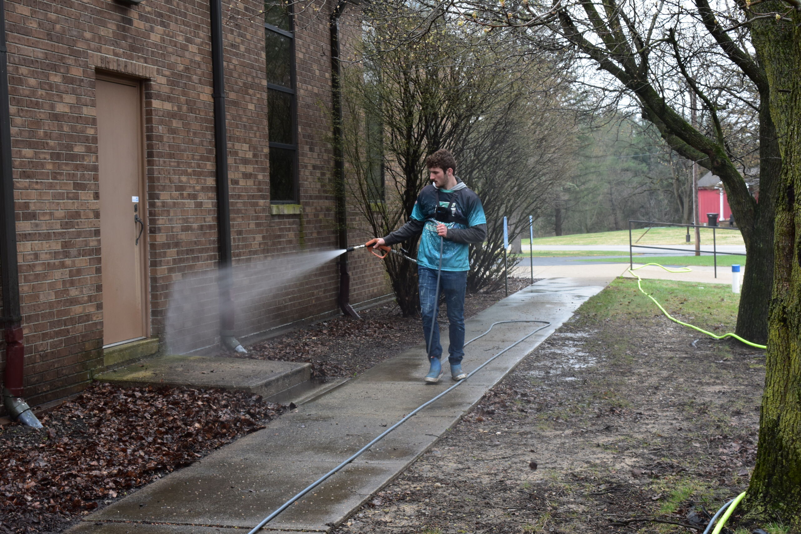 Prime & Shine technician pressure washing a brick commercial building exterior in Northern Indiana