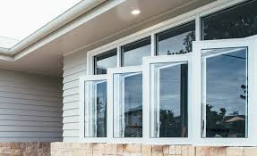 Clean streak-free exterior windows on a modern home with white trim and stone veneer after professional window cleaning